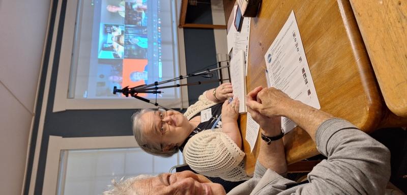 hybrid meeting 2 women in room and screen of zoom meeting